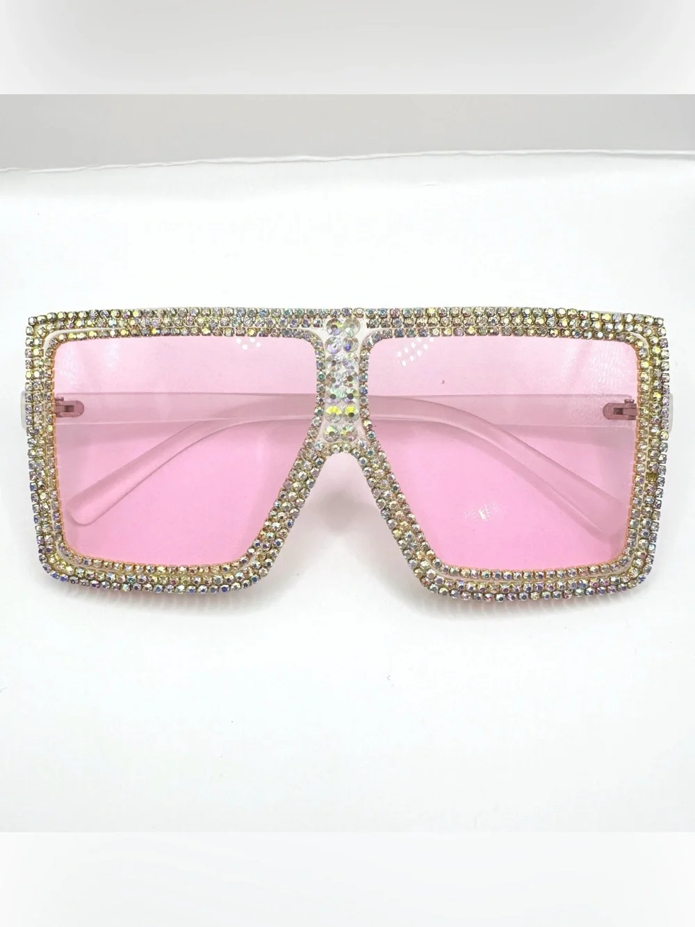 Oversized square flat-top sunglasses feature translucent pink lenses and frames